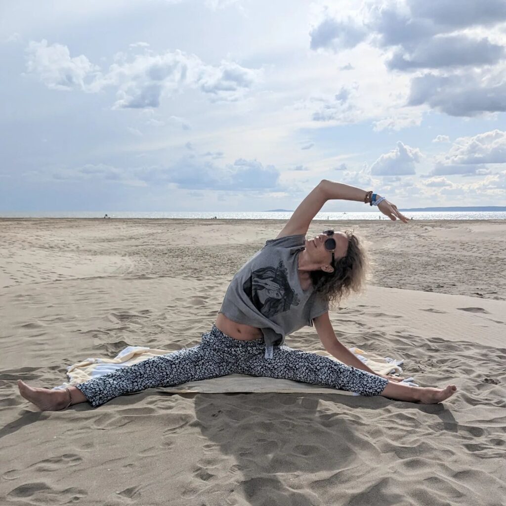 žena cvičí jógu na pláži